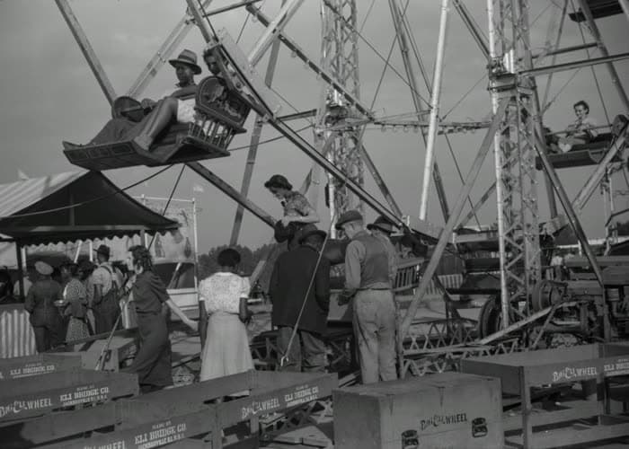 The swing ride mid-turn, riders above the crowd