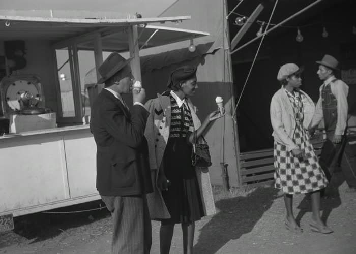 A couple in their best clothes, sharing an ice cream